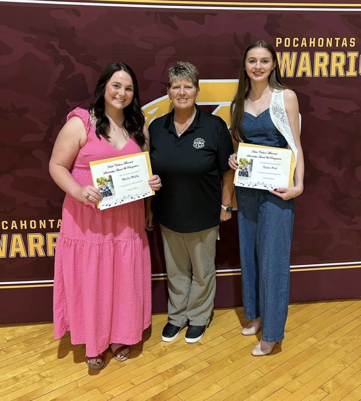 Two Pocahontas High School scholarship recipients holding their certificates with a GVSA member